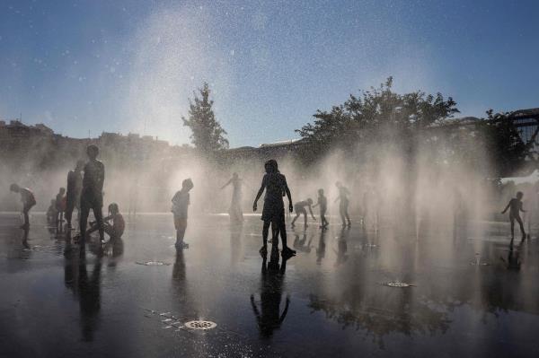 People cool off at a fountain in the Madrid Rio park amid heat wave conditions in Madrid in July 2024. (AFP-Yonhap)