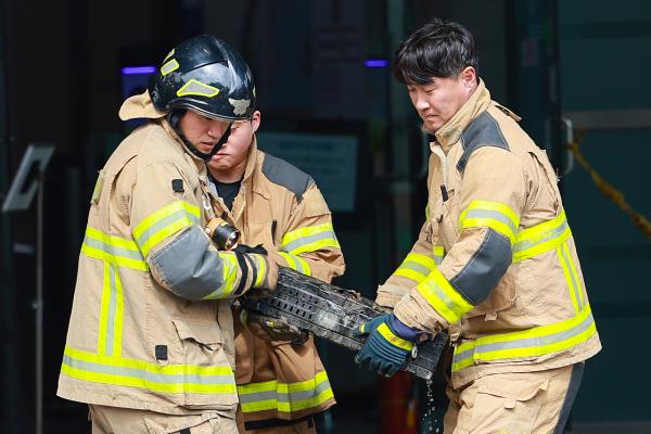 Firefighters move a lithium-ion battery burned in a fire at the National Information Resources Service in Daejeon on Saturday. (Yonhap)