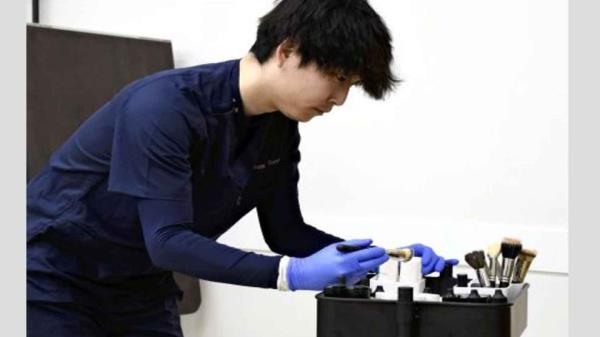 Yoshihiro Naoshima uses a mortuary makeup kit.   (Japan News)