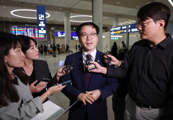South Korean Trade Minister Yeo Han-koo (center) answers reporters