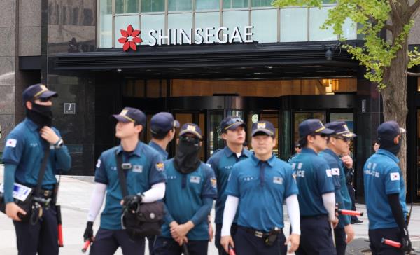 Police are seen deployed to Shinsegae Department Store near Seoul’s Myeong-dong shopping district on Aug. 5 after a bomb threat triggered an emergency response. (Newsis)
