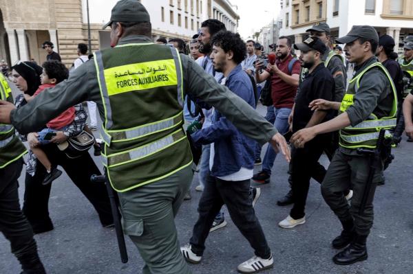 Moroccan security forces escort protesters away from the parliament building in Rabat, Morocco, Sunday. (AFP-Yonhap)