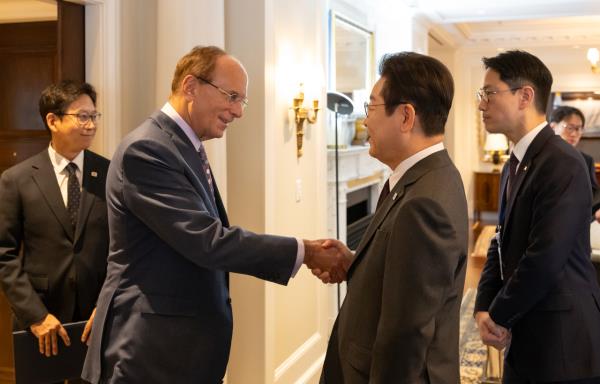 South Korean President Lee Jae Myung (second from right) and Chairman and CEO of BlackRock Larry Fink (second from left) shake hands during a meeting in New York on Monday. (Pool photo via Yonhap)
