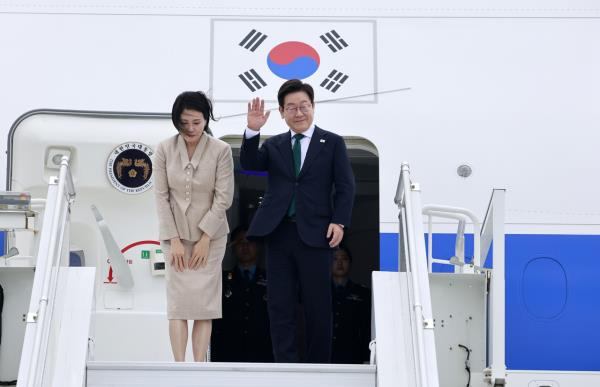 President Lee Jae Myung and first lady Kim Hea Kyung wave from Air Force One at New York’s JFK Airport on Thursday after completing their visit to the US. (Yonhap)