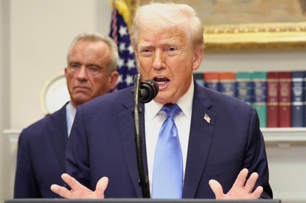 US President Donald Trump, in front of US Secretary of Health and Human Services Robert F. Kennedy Jr., delivers remarks at the White House in Washington, Monday. (Reuters-Yonhap)
