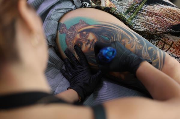 This photo shows a tattoo artist at work at a tattoo shop in Seoul on Aug. 27. (Yonhap)