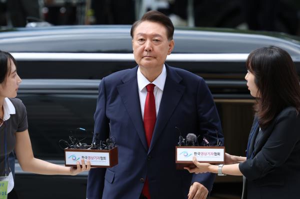 Former President Yoon Suk Yeol enters the Seoul Central District Court in Seocho-gu, Seoul, on July 9, 2025, to attend a court hearing on his arrest warrant, while responding to reporters’ questions. (Herald DB)