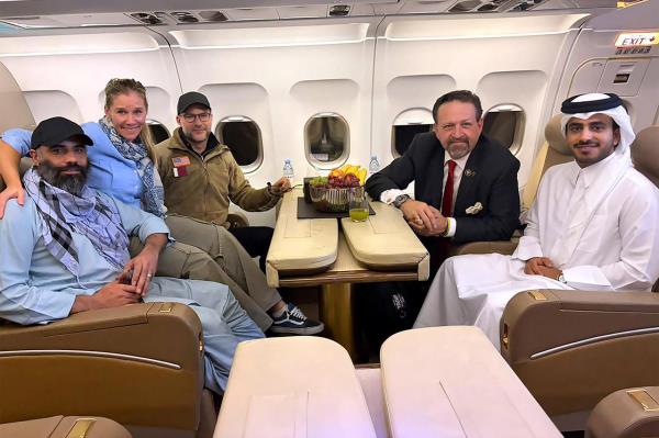 Amir Amiri (left), a US citizen freed from an Afghan prison, poses for pictures with members of the US delegation that negotiated his release, on board a plane in Kabul, Afghanistan, Sunday.   (UPI-Yonhap)