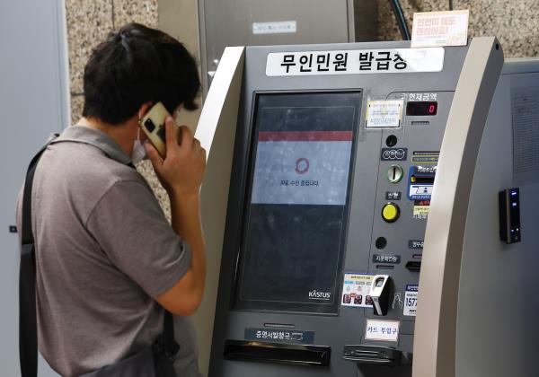 A citizen makes a phone call in front of an unmanned civil service kiosk at a Seoul subway station as the service is disrupted on Saturday. (Yonhap)